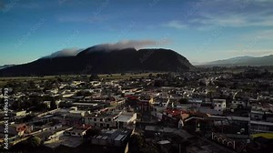 4K drone footage over village at sunset with mountain range on the back in Tlachichuca, México. Mid angle, traveling movement.