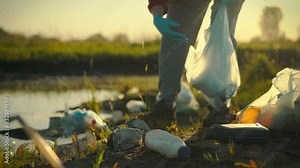 A caring young man collects garbage, sorting plastic waste into bags for subsequent disposal and recycling. Sustainable recycling of materials for reuse