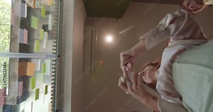 Business team handing sticky notes each other and writing information on them about the project. They place the notes over a glass wall at the working room.