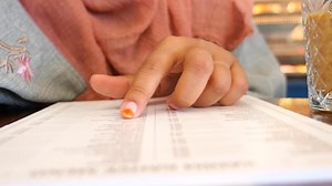 Download women hand reading a food menu at cafe. for free