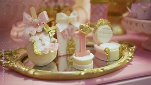 candy table at princess-themed party for girl's 1st birthday with pink and gold