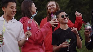 Group of Happy young man and woman friends having fun at the summer party. International Group of friends dancing at outdoor party relaxing together enjoy music and drinking cocktails