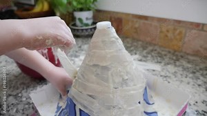 Little boy creating volcano out of paper mache for a science project
