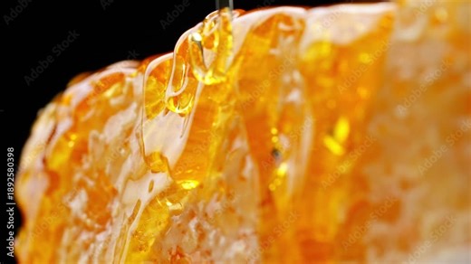 Honeycomb with dripping honey, shot in close-up with a golden glow