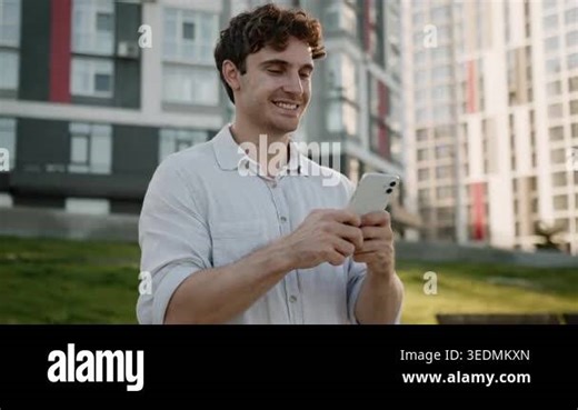 Happy smiling Caucasian business man holding mobile phone looking in smartphone joyful businessman smile enjoy good news message web net scrolling male guy developer using cellphone in city downtown Stock Video Footage - Alamy