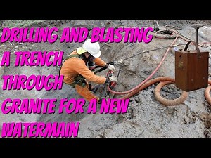 Blasting a trench through Granite for a new water main.