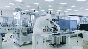 Sterile High Precision Manufacturing Laboratory where Scientists in Protective Coverall's Use Computers and Microscopes, doing Pharmaceutics, Biotechnology and Semiconductor Research