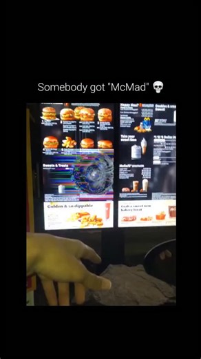 Yoo Humor on Instagram: "This viral clip captures a heavily damaged drive-thru menu, where the screen has been smashed in a sharp circular pattern. When the customer asks what happened, the employee responds with the now-iconic phrase: "Somebody got McMad." This witty play on words perfectly utilizes the brand's "Mc" prefix to turn a moment of property damage into a legendary piece of workplace humor, highlighting the unpredictable and sometimes intense nature of the service industry in a lighth