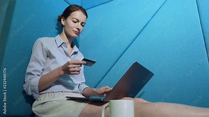 Young woman hopping online with credit card on laptop.