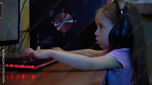 A child with headphones plays an online video game on the computer. The problem of Computer Game Addiction in Children