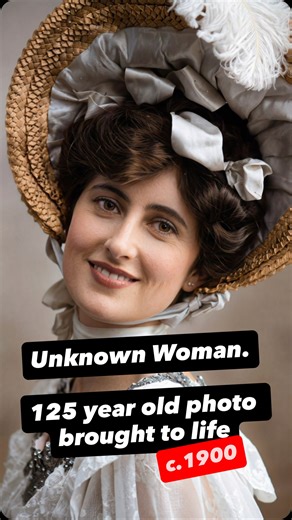 An unknown woman photographed around 1900, dressed in formal daywear typical of the late Victorian to early Edwardian period. She wears a wide straw hat lined with gathered white fabric and feathers, secured beneath the chin, paired with a high lace bodice adorned with fine embroidery and beadwork. A wrapped neck scarf and structured neckline reflect modesty, precision, and careful presentation expected in studio portraits of the time. Women dressed in this manner often lived in towns or expandi