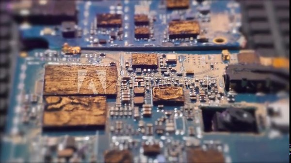 Surface of spent motherboards, melted and overloaded microchips close up, tracking shot low angle blurred background.