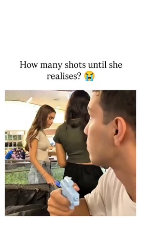 street_decode on Instagram: "The post features a 33-second video of a young man squirting water from a blue pistol at an oblivious woman in a mall food court, captioned "How many shots until she realises? ", which has amassed over 9,700 likes and 11.5 million views in under 24 hours. Frame-by-frame analysis shows the pistol clearly visible from the first second, with the woman glancing at it without reaction, confirming the clip as a staged prank where participants likely feign ignorance for com