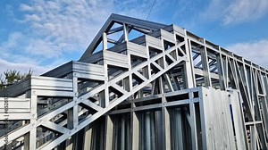 Lightweight steel thin-walled structures. Frames for warehouses, garages or houses. Structure of a steel frame for construction against the sky