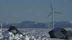 Windmills in winter landscape. Various windmills beautifully framed against snow covered moors, rolling hills and peaks in a frosty winter landscape on a bright sunny winter day in Norway