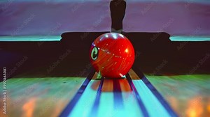A close-up of a bowling ball on a lane, ready for a game.