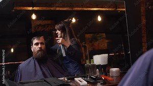 woman barber shearing a young man in a barbershop, slow motion
