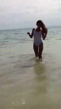 Sexy lady in see through swimsuit on beach