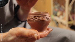 Shaping clay with skill. Handcrafting ceramic forms. Traditional pottery work. Creative clay molding. Artistic ceramist's creations. Master potter working in workshop creating pot or vase.