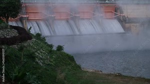 Hydroelectric dam, floodgate with flowing water through gate and open springway at Kew Lom Dam, Lampang, Thailand. Dam