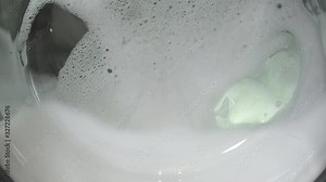 The washing machine on a black, dark background. Spinning drum. The washing process in the washing machine.