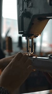 Seamstress working on sewing machine, stitching textile, fabric. Sewing workshop background. Concept for atelier, repairing and tailoring clothes. Handcraft manufacturing. Camera's span Vertical shot.