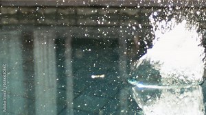 Underwater splash erupts in pool as body hits surface, bubbles and turbulence visible, slow motion sparkling glow with glistening gleam