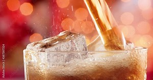 Glass of cola. Ice cola with splashing bubbles slow motion on a blurry light ,blurry background.