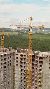 Drone fly over construction new modern building work builders and technicals. High height of the multi-floor flat house. Vertical shot.