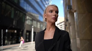 androgynous model is walking alone on street of modern city, man with female makeup