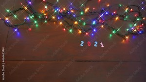 stop motion, time lapse, transition to the new year 2021 2022, with colorful numbers and colorful festive christmas lights on intermittently, with the date 2022 pushing the old year away.