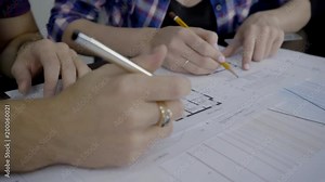 On desktop designers prepare documents for the interior design. Close-up on table are papers with schedules and layout over which specialists in field of construction are building.