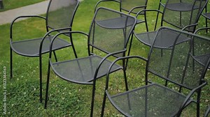 Several empty metal chairs placed on grass, creating an inviting outdoor setting for relaxation