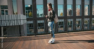 Young woman student with prosthetic leg walking in university campus. Woman with bionic leg. Woman with leg prosthesis equipment