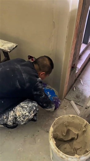 Person smoothing plaster on wall corner surface