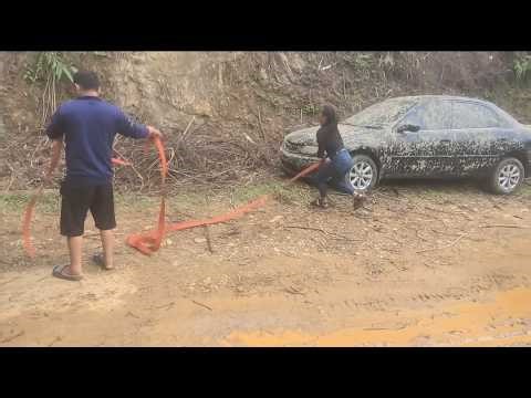 A scene of a dirty black car being cleaned and repaired to make it roadworthy