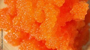 Tobiko: Japanese cuisine staple, fish roe from Tobiuo flying fish. Small eggs, vibrant colors, crunchy texture, slightly salty, briny flavor. Seafood concept. Food background. 4K UHD.