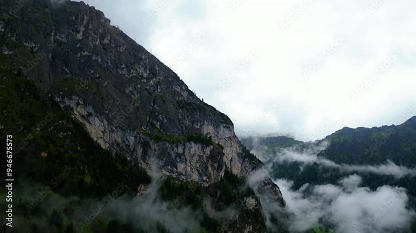 An aerial view of Camping Marmolada Malga Ciapela with the majestic Marmolada peak in the background, captured by a drone. Nestled in the heart of the Dolomites