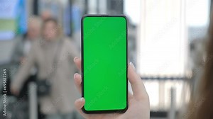 Airport Terminal: Businesswoman Working on Green Chroma Key Screen Mobile Smartphone, Waits for a Plane Flight. Female Does Online Remote Work in Boarding Lounge of Airline Hub.