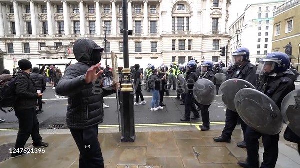 Crowd control police officers move protesters away from Whitehall...