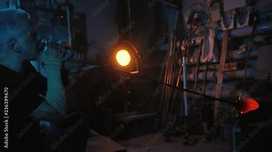 Glassblower free blowing glass at glassblowing factory