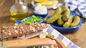 Appetizing Dutch herring in a sandwich. Toast with Dutch herring, onions, pickles. Traditional rustic appetizer with seafood. Popular food in the netherlands. Slowmotion