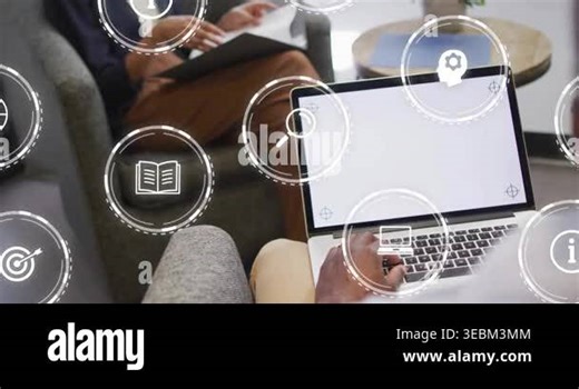 Colleagues reviewing file and typing in lounge causing icons around screen indicating teamwork. Collaboration, innovation, digital, workspace, learning, communication, modernization Stock Video Footage - Alamy