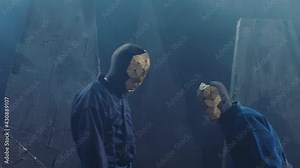 Mystic footage of metal masked man . Epic scene of people with triangle shape mask and black costume cloak . Unfaced men watching or following something or someone . Anonymity or Anonym follower theme