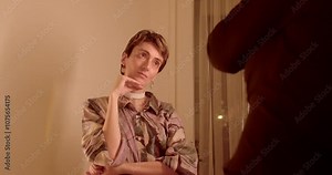 Woman posing during photoshoot. A contemplative figure strikes a pose in a creatively lit environment, showcasing unique artistic elements