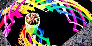 Artist creates paintings with a swinging paint bucket