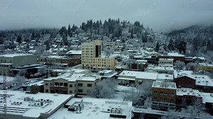 Ashland, Oregon, USA, Winter 2023. Downtown. On a snow day we are moving from East to West along main street. Seen is Ashland Springs Hotel and the Oregon Shakespeare Festival's Elizibethan Theater.
