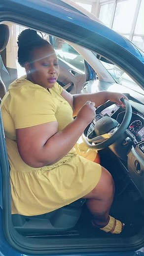Woman Driving in Yellow Dress: A Daytime Car Journey