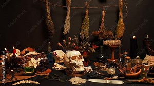 Witch's ceremony with ritual magic items. Magic symbols and tools. Composition with black magic candles, dry weeds, animals bones and potion vials. Halloween concept.