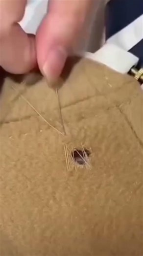 The process of sewing a fabric using a needle and thread